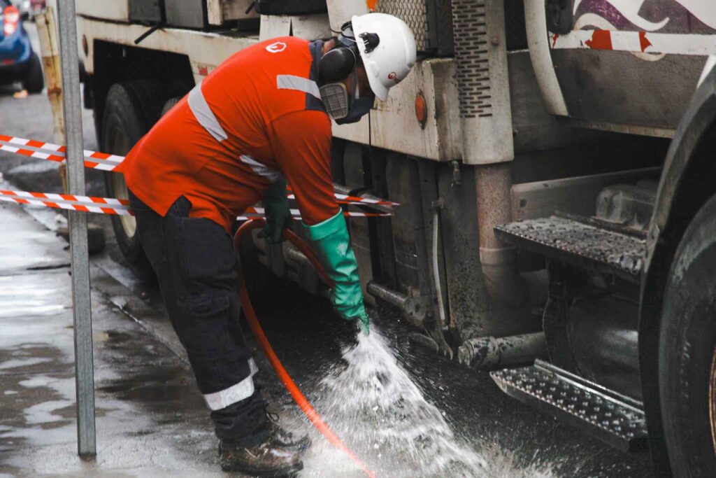 Personal Municipal realiza trabajos para evacuar el agua de una calle de Guayaquil inundada. 