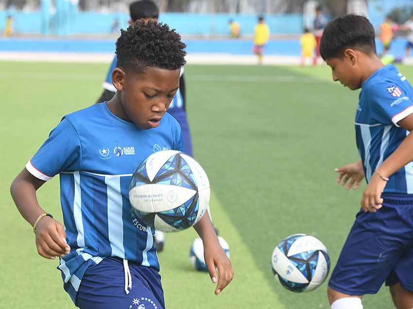 Un niño beneficiario de las escuelas sociodeportivas del Municipio de Guayaquil, domina la pelota durante un entrenamiento.