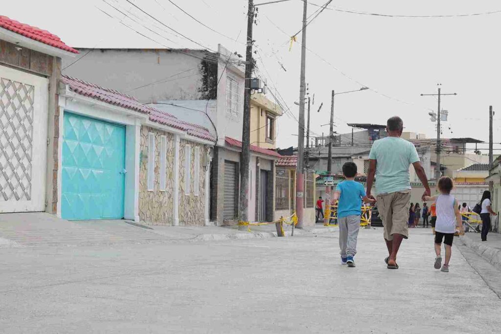 Una familia camina por una de las calles de la Alborada que fue mejorada. 