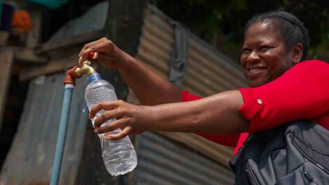 Una moradora de la cooperativa Janeth Toral abre una llave para obtener agua potable.