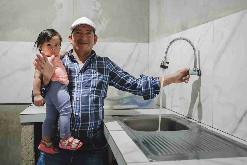 Un habitante del sector muestra cómo ha mejorado la presión del agua potable.