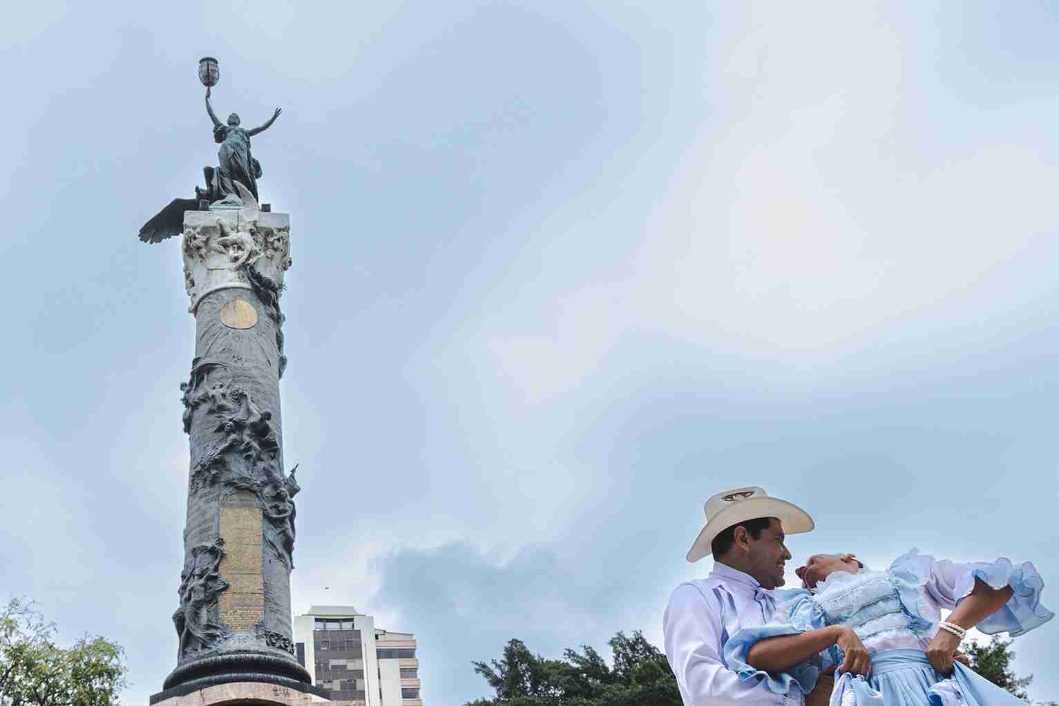 Una pareja de bailarines muestra su destreza junto a la Columna de los Próceres, en el Parque Centenario.