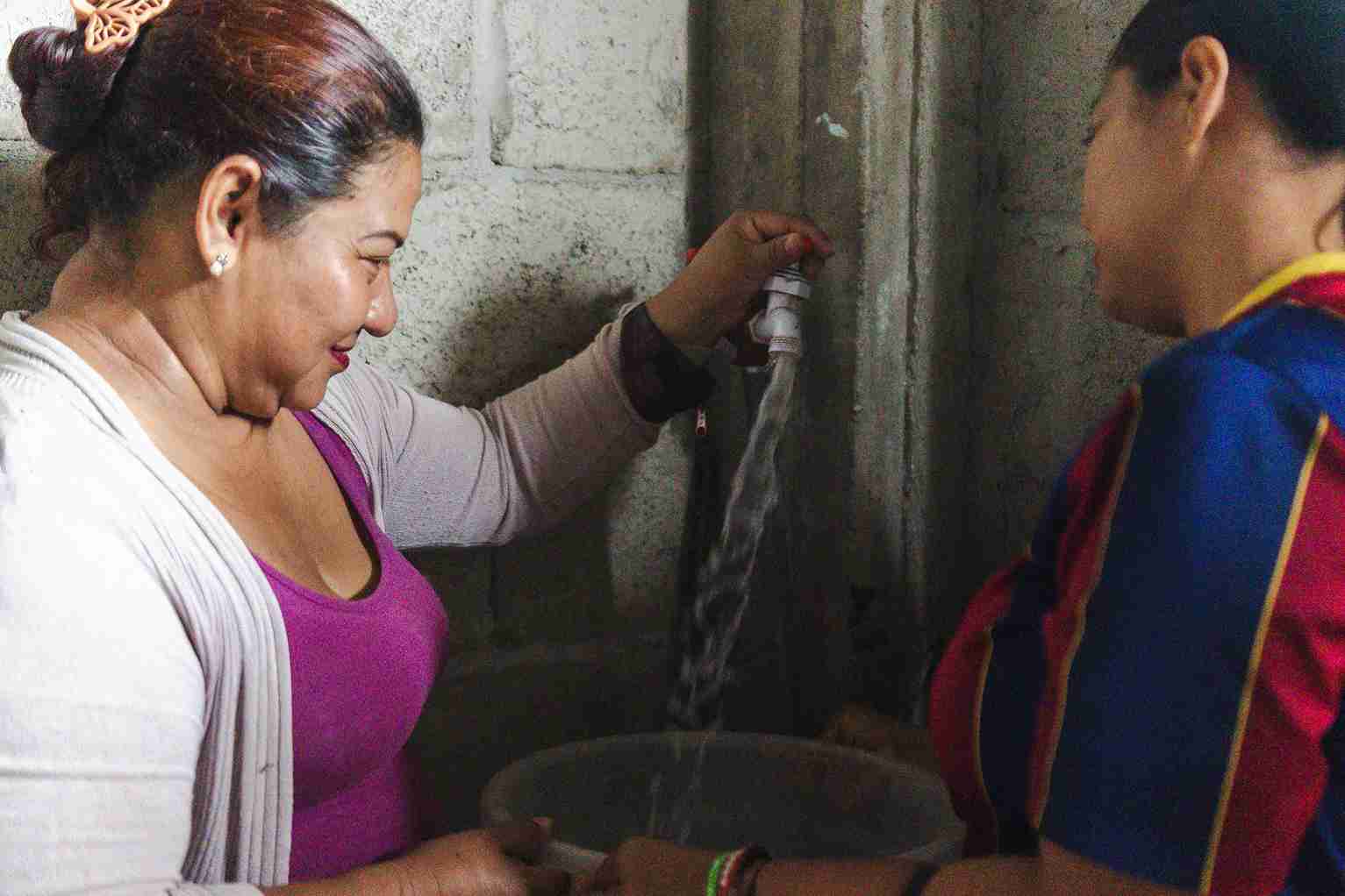 Una moradora de Sergio Toral II recibe el servicio de agua potable en su domicilio