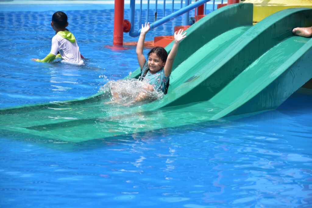 Una niña se distrae en uno de los juegos acuáticos de las piscinas municipales.